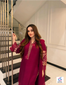 Pakistani actress Aiman Khan stands confidently in a beautiful traditional dress during a fashion photoshoot.