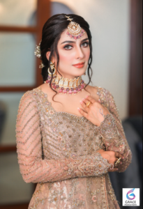 Pakistani actress Ayeza Khan smiling during a glamorous portrait session in 2026.