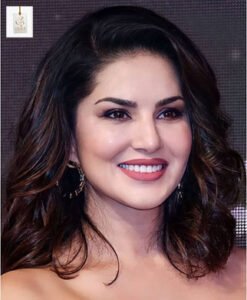 Sunny Leone biography profile featuring the actress posing in an elegant outfit during a public appearance, smiling confidently at the camera.