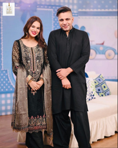 Zohreh Amir smiling in a stylish outfit at a public event