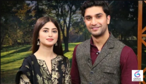 Ahad Raza Mir smiling during a promotional photoshoot in a modern formal outfit.