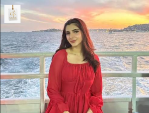 Elegant portrait of Pakistani actress Vaneeza Sattar wearing a soft pink outfit while posing confidently in a modern café setting.